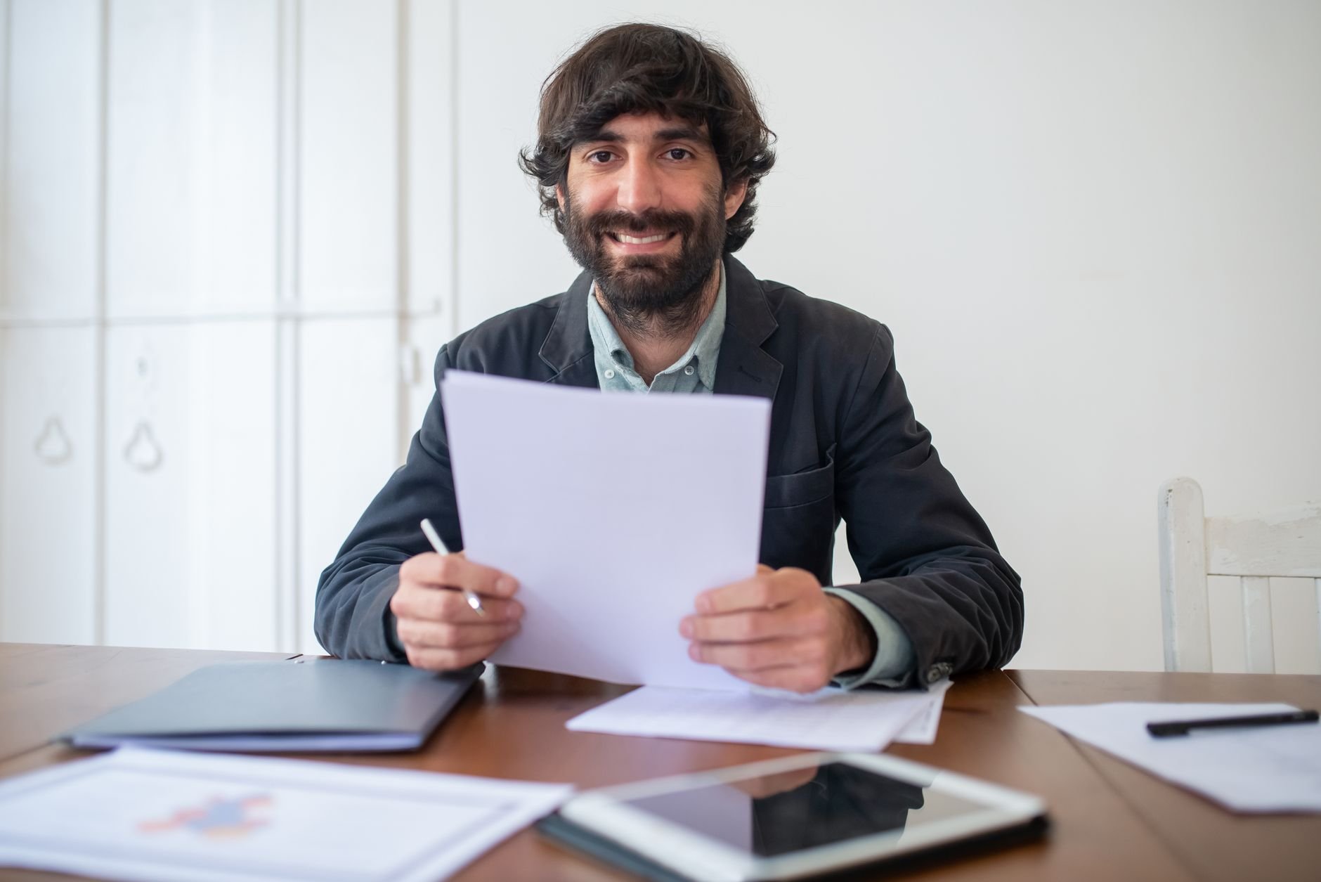 Hiring manager reviewing candidate materials with a confident smile
